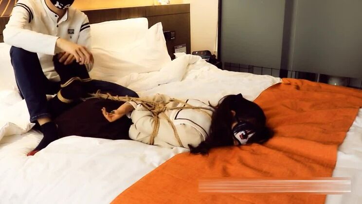 ツインテールの少女が縛られ、ボールギャグを咥えさせられる